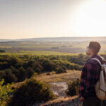 a man standing on a mountain as the sun sets 2023 11 27 05 15 05 utc easy resize.com