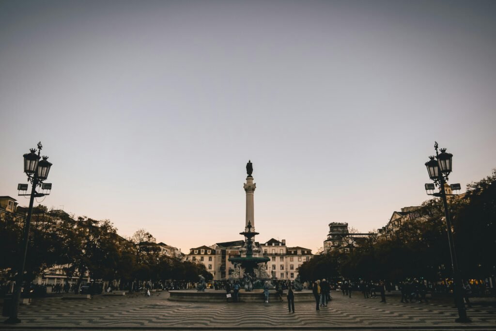 A captivating view of Rossio Square in Lisbon at twilight with the bustling urban ambiance.