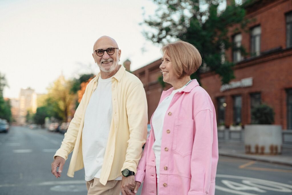 Happy senior couple enjoying a walk together outdoors, holding hands and smiling.