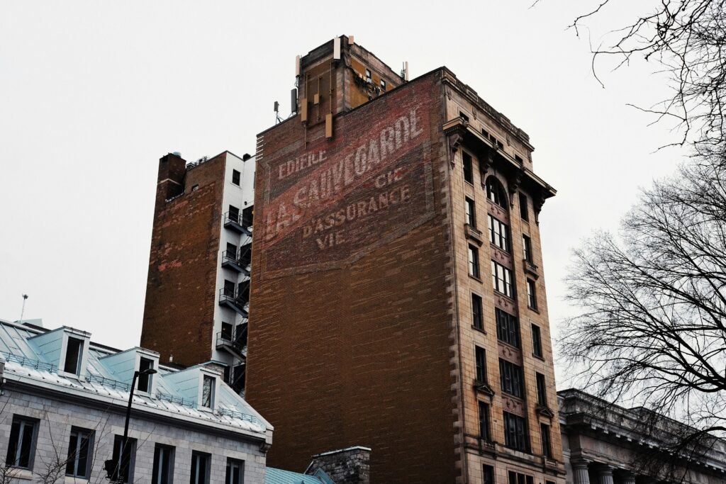 Old brick building with faded vintage signage. Clear urban winter scene.